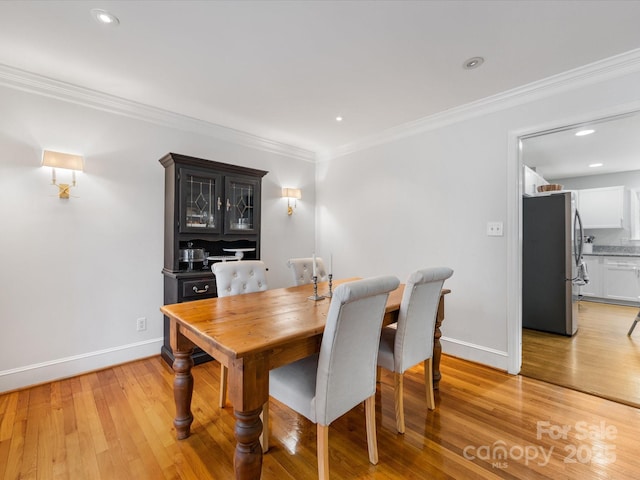 dining room featuring crown molding and light hardwood / wood-style floors