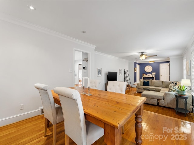 dining area featuring crown molding, wood-type flooring, and ceiling fan