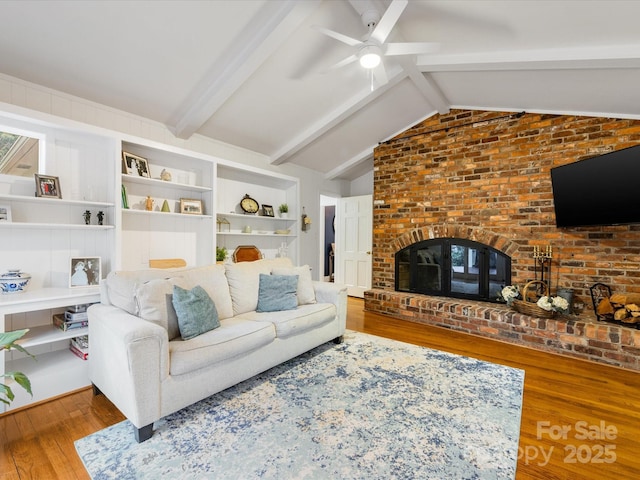 living room featuring wood-type flooring, vaulted ceiling with beams, and built in shelves