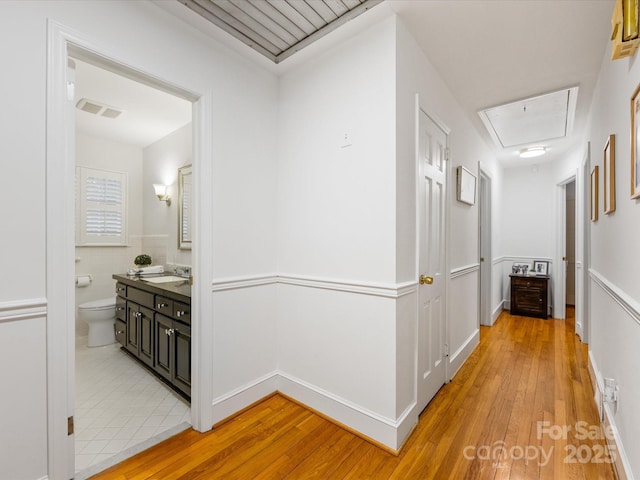 corridor featuring sink and light hardwood / wood-style floors