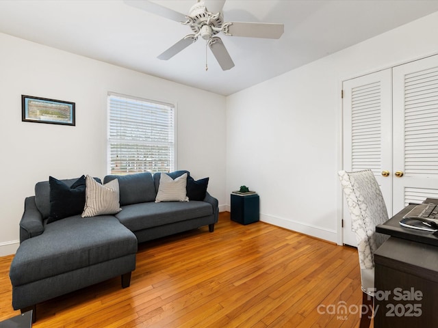 living room featuring hardwood / wood-style floors and ceiling fan