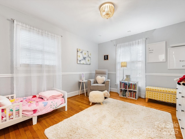 bedroom with wood-type flooring and multiple windows