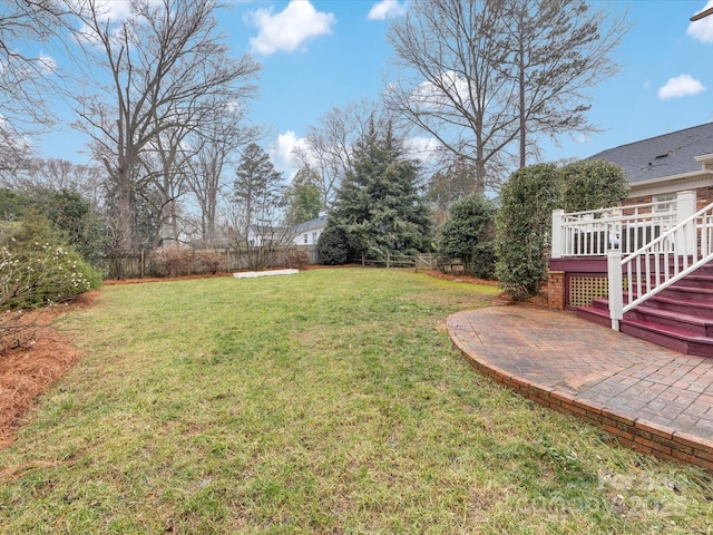 view of yard featuring a wooden deck and a patio