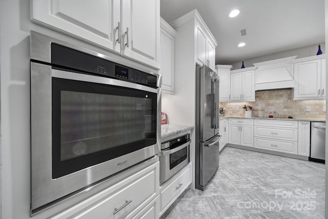 kitchen with appliances with stainless steel finishes, custom exhaust hood, and white cabinets