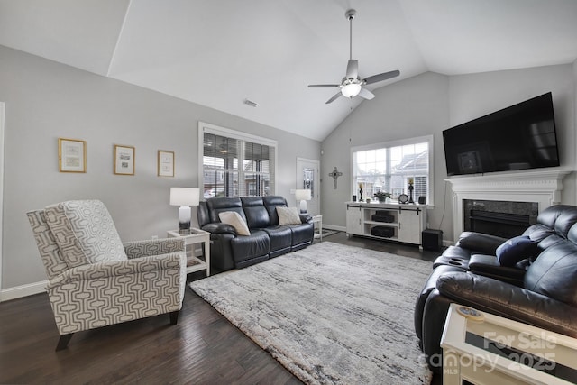 living room featuring dark wood-type flooring, ceiling fan, a premium fireplace, and high vaulted ceiling