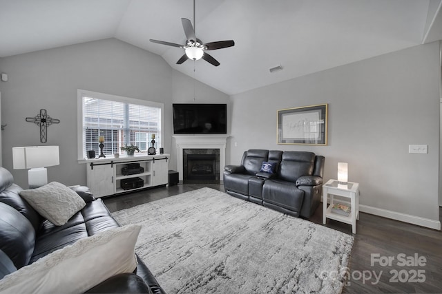 living room with a premium fireplace, lofted ceiling, dark hardwood / wood-style floors, and ceiling fan