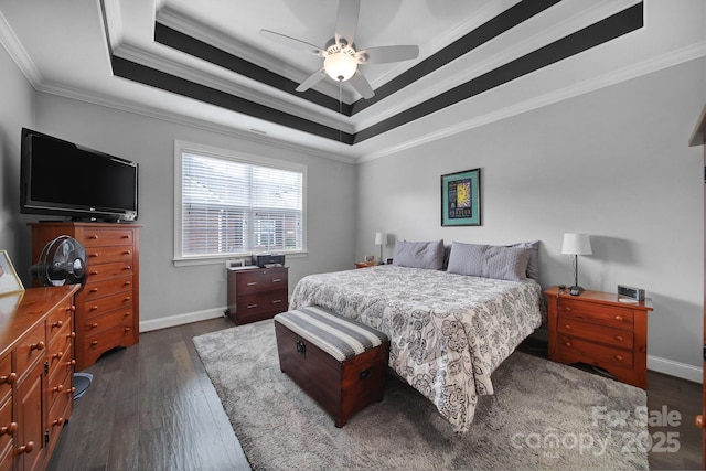 bedroom with ornamental molding, ceiling fan, dark hardwood / wood-style flooring, and a tray ceiling