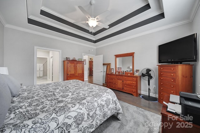 bedroom featuring dark hardwood / wood-style floors, ceiling fan, a tray ceiling, and crown molding