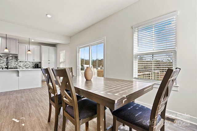 dining space featuring sink and light wood-type flooring