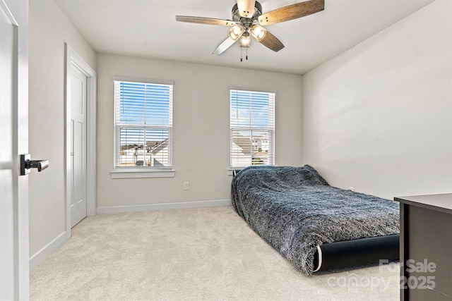 bedroom featuring light carpet, multiple windows, and ceiling fan