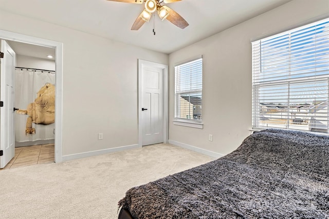 carpeted bedroom with ceiling fan and ensuite bath