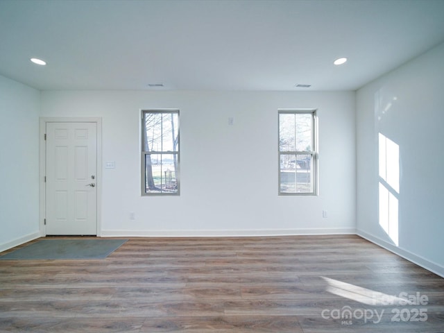 spare room featuring a healthy amount of sunlight and hardwood / wood-style floors