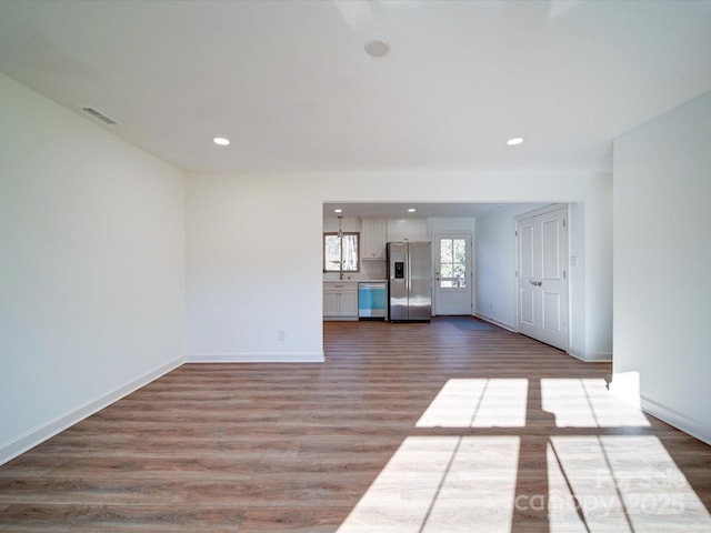 unfurnished living room with hardwood / wood-style floors and sink