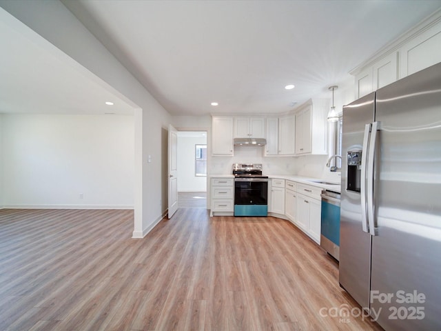 kitchen featuring sink, light hardwood / wood-style flooring, appliances with stainless steel finishes, white cabinetry, and decorative light fixtures