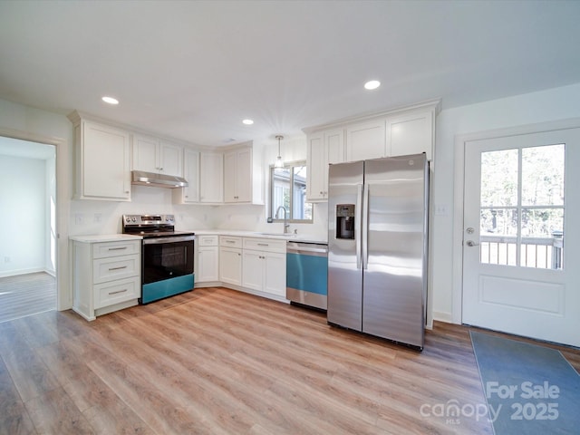 kitchen featuring sink, hanging light fixtures, stainless steel appliances, light hardwood / wood-style floors, and white cabinets