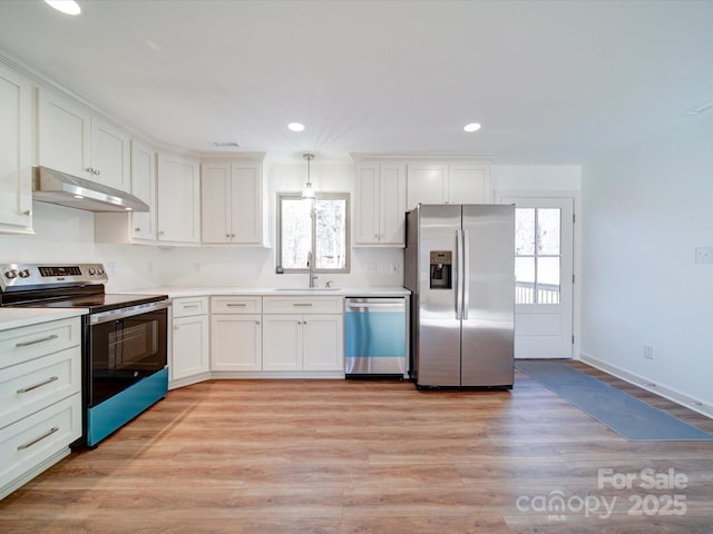 kitchen featuring sink, white cabinetry, decorative light fixtures, light hardwood / wood-style flooring, and stainless steel appliances