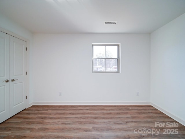 unfurnished room with hardwood / wood-style floors