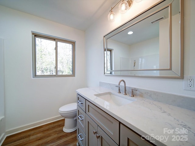 bathroom with vanity, wood-type flooring, toilet, and walk in shower