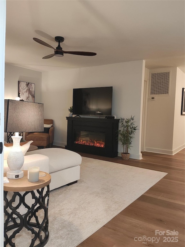 living room featuring hardwood / wood-style floors and ceiling fan