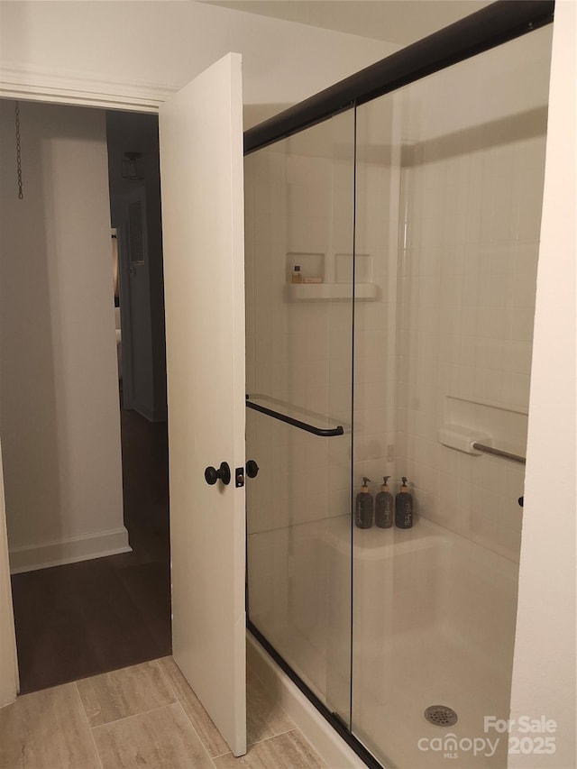 bathroom with hardwood / wood-style flooring and walk in shower