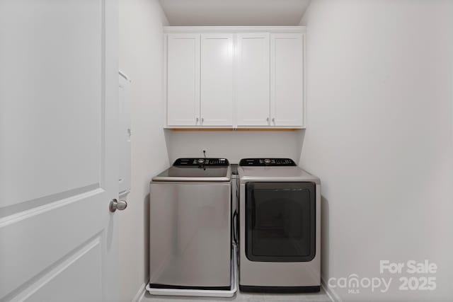 laundry area with cabinets and washer and clothes dryer