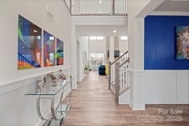 foyer featuring a towering ceiling and light hardwood / wood-style flooring