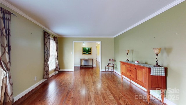 interior space featuring radiator, wood-type flooring, and ornamental molding