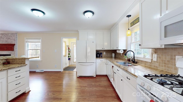 kitchen with white cabinetry, white appliances, sink, and hanging light fixtures