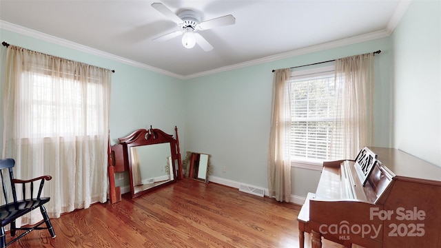 home office with ceiling fan, a wealth of natural light, ornamental molding, and wood-type flooring