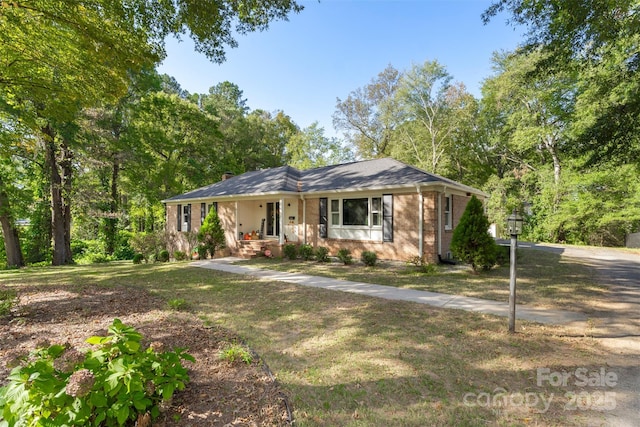 ranch-style house featuring a front yard and covered porch