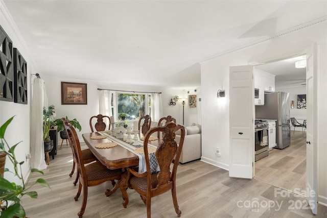 dining area featuring crown molding and light hardwood / wood-style floors