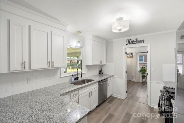 kitchen featuring stainless steel appliances, light stone countertops, sink, and white cabinets