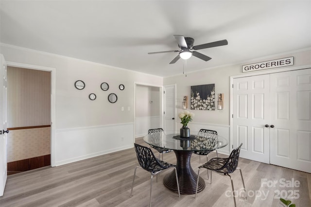 dining space with hardwood / wood-style flooring, ceiling fan, and crown molding