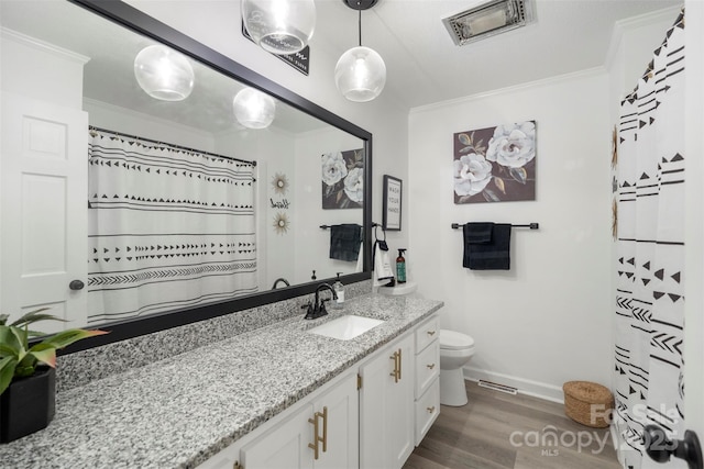 bathroom with crown molding, vanity, toilet, and hardwood / wood-style flooring