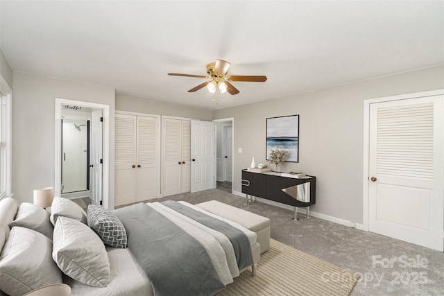 carpeted bedroom with ceiling fan and two closets