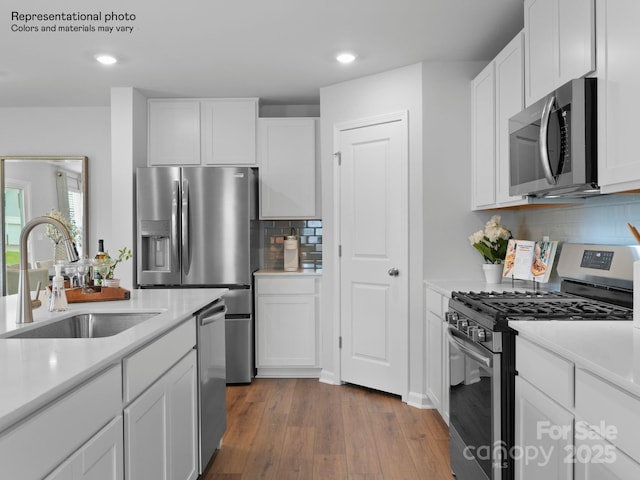 kitchen featuring tasteful backsplash, sink, white cabinets, and appliances with stainless steel finishes