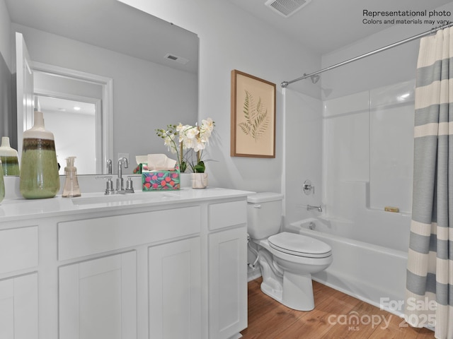 full bathroom with vanity, hardwood / wood-style flooring, toilet, and shower / bath combo with shower curtain