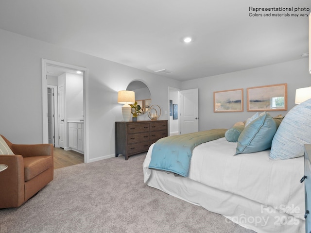 carpeted bedroom featuring ensuite bathroom