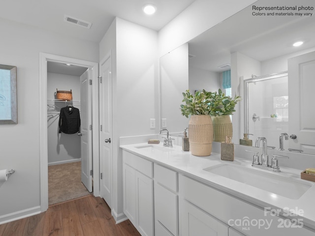 bathroom featuring vanity, wood-type flooring, and a shower with door