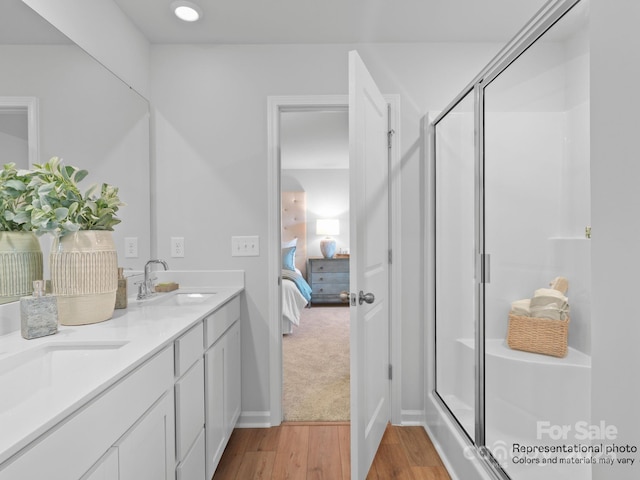 bathroom with vanity, a shower with door, and hardwood / wood-style floors