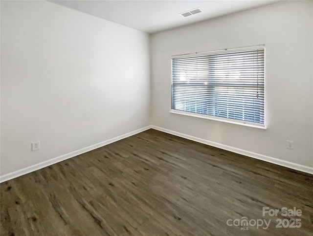 unfurnished room with dark wood-type flooring