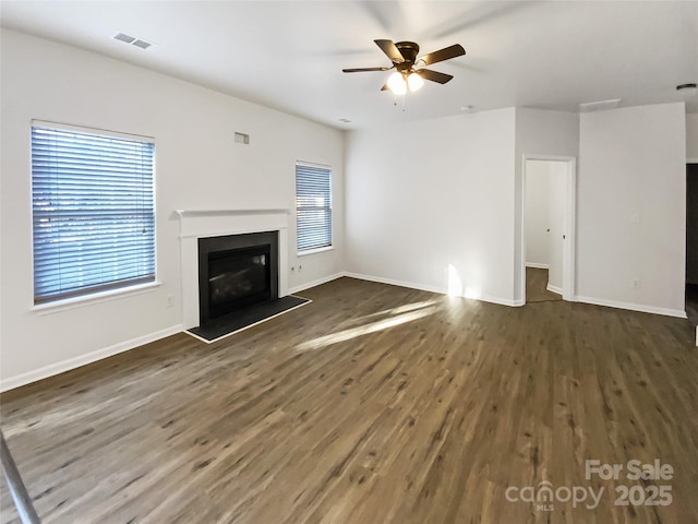 unfurnished living room featuring dark hardwood / wood-style floors and ceiling fan