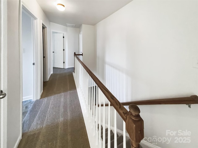 hallway featuring dark colored carpet