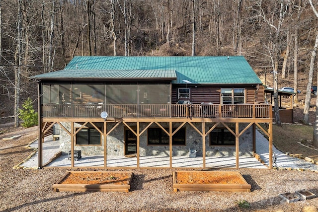 rear view of property with a patio and a sunroom