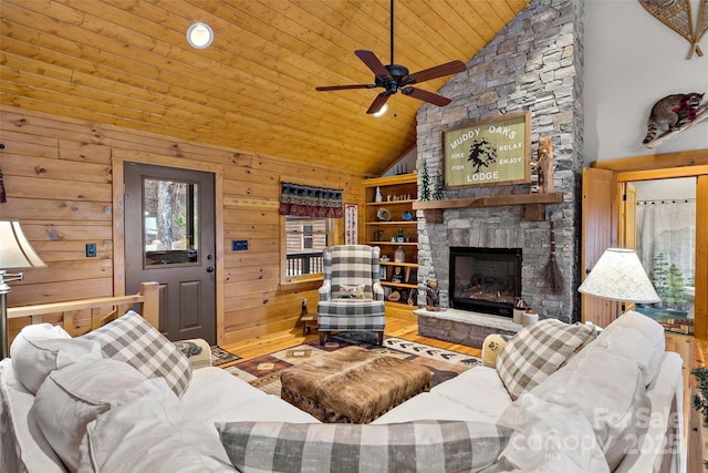 living room featuring a fireplace, wood ceiling, wood walls, wood finished floors, and high vaulted ceiling