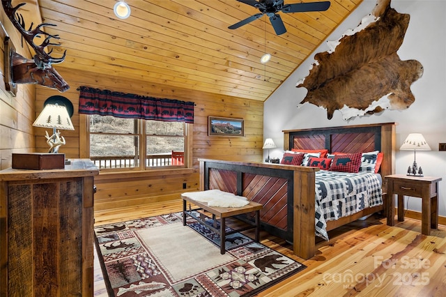 bedroom with vaulted ceiling, wood ceiling, wooden walls, and hardwood / wood-style floors