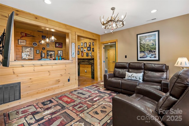 living room with recessed lighting, visible vents, an inviting chandelier, and wood finished floors