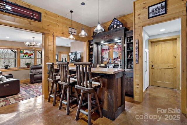 108 Oak Winds Dr Unit 202S, Old Fort, NC 28762 - indoor bar featuring finished concrete floors, wooden walls, hanging light fixtures, a chandelier, and baseboards
