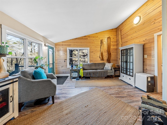 living room with hardwood / wood-style flooring, lofted ceiling, and wooden walls