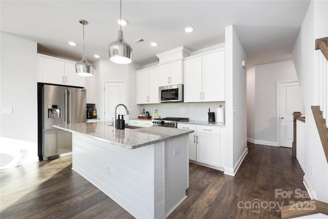 kitchen featuring white cabinetry, stainless steel appliances, sink, and a center island with sink